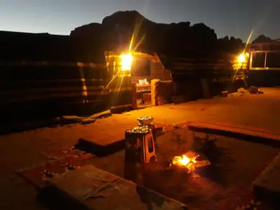 a night view of a room with a fire at Wild of Wadi Rum in Wadi Rum