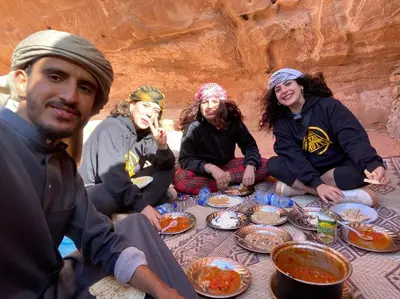 a group of people sitting around a table eating food at DESERT HELO lUXURY CAMP & TOUR in Wadi Rum