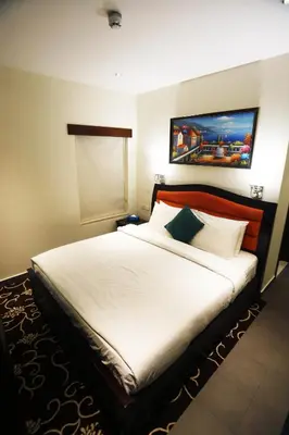 a bedroom with a large bed with white sheets at Naylover Hotel Suites in Amman