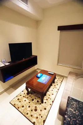 a living room with a coffee table and a flat screen tv at Naylover Hotel Suites in Amman