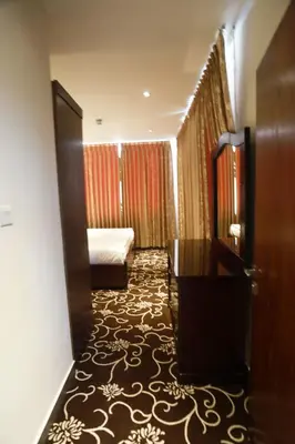 a hotel room with a bed and a door at Naylover Hotel Suites in Amman