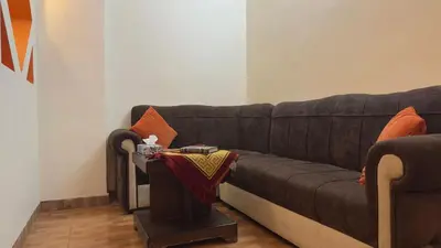 a brown couch in a living room with a table at Al Riyati Hotel Apartments in Aqaba