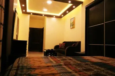 a bedroom with a bed and a living room with a couch at Al Riyati Hotel Apartments in Aqaba