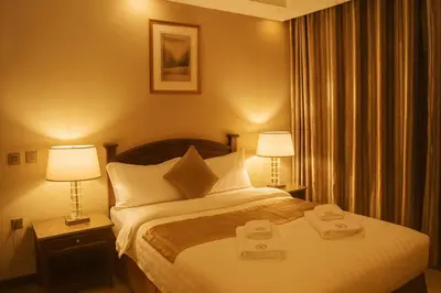 a hotel room with a bed with two towels on it at Aljamal Hotel in Amman