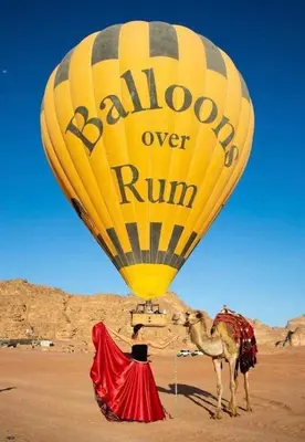 a yellow hot air balloon and a camel in the desert at Panorama Wadi Rum in Wadi Rum