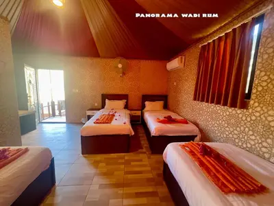 a bedroom with three beds in a room at Panorama Wadi Rum in Wadi Rum