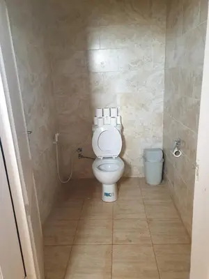 a small bathroom with a toilet and a bucket at Wadi Rum Desert Camp in Wadi Rum