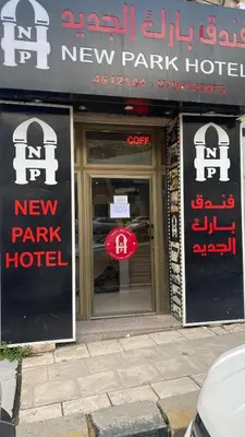 a new park hotel with a sign on the doors at New Park Hotel in Amman