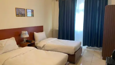a hotel room with two beds and a window at New Park Hotel in Amman
