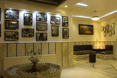 a room with pictures on the wall and a fountain at Arab Tower Hotel in Amman