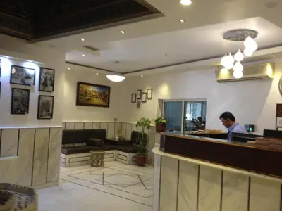 a man standing at the counter of a restaurant at Arab Tower Hotel in Amman