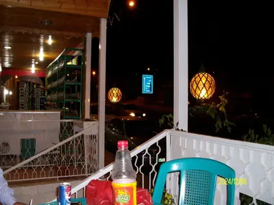a table and a chair on a balcony at night at Mussa Spring Hotel in Wadi Musa