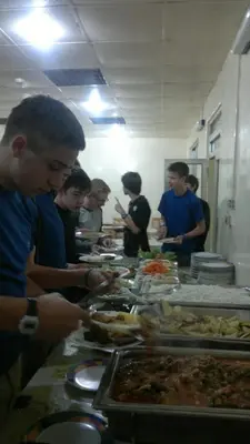 a group of people standing around a buffet line preparing food at Mussa Spring Hotel in Wadi Musa