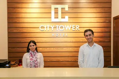 a man and a woman standing in front of a hotel at City Tower Hotel in Aqaba