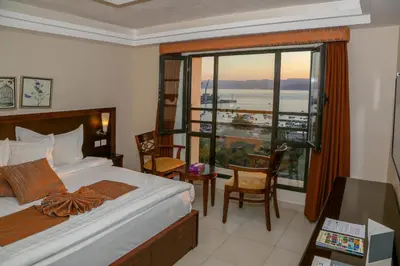 a bedroom with a bed and a large window at City Tower Hotel in Aqaba