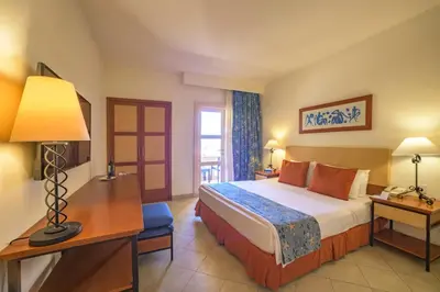 a hotel room with a bed and a desk with a lamp at Marina Plaza Hotel, Tala Bay in Aqaba