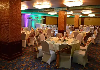 a banquet room with white tables and chairs at Larsa Hotel in Amman