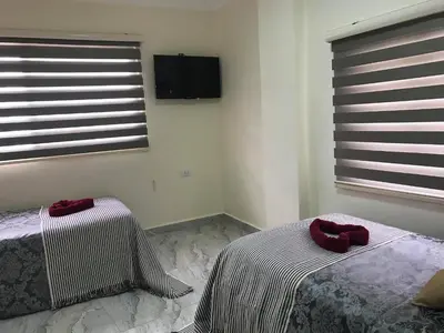 a bedroom with two beds with red pillows on them at Jordan Tower Hotel in Amman