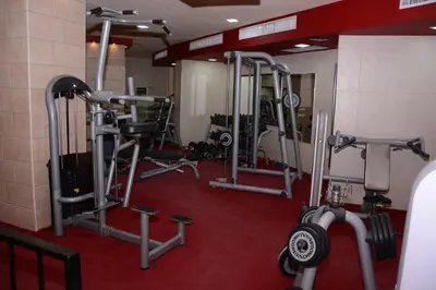 a gym with several tread machines in a room at Rojina Hotel in Amman