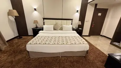 a bedroom with a large bed in a hotel room at Rojina Hotel in Amman