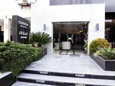 a lobby of a building with a door with plants at Granada Suites Hotel in Amman
