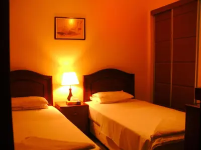 a bedroom with two beds and a lamp on a night stand at Al Rashid Hotel in Wadi Musa