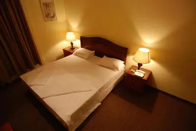 a bedroom with a bed with two night stands and two lamps at Al Rashid Hotel in Wadi Musa
