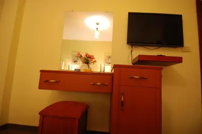 a room with a tv and a dresser with a dresser at Al Rashid Hotel in Wadi Musa