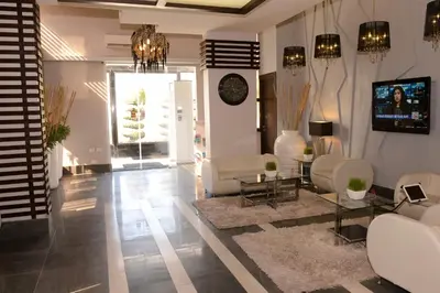 a living room with white furniture and a tv at Crystal Suites in Amman