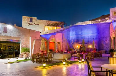 a restaurant with tables and chairs in front of a building at Petra Guest House Hotel in Petra