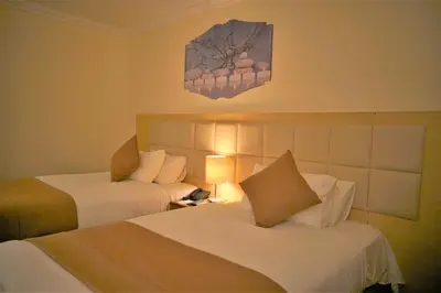 a hotel room with two beds and a clock on the wall at Silk Road Hotel in Wadi Musa