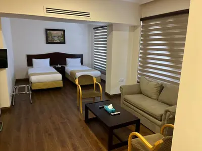 a living room with two beds and a couch at Rozana Hotel in Amman