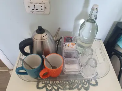 a tray with cups and a bottle on a table at The Little B&B on the Hill in Wadi Musa