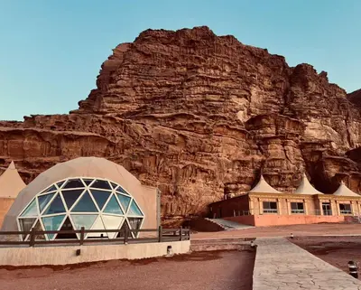 a building in front of a rocky mountain at Beyond Wadi Rum Camp in Wadi Rum