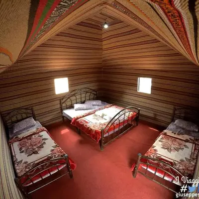 a room with two beds in a wooden room at Wadi Rum Bedouin Way Camp in Wadi Rum