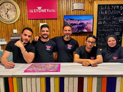 a group of men standing behind a table at The Sydney Hotel in Amman