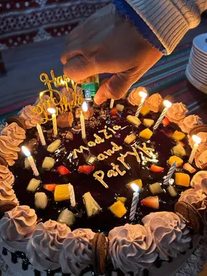 a person lighting candles on a birthday cake at Bedouin Tours Camp in Wadi Rum