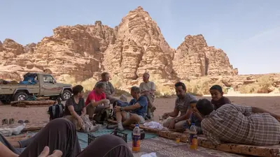 a group of people sitting around in the desert at Wadi Rum Fire Camp in Wadi Rum