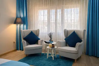 a bedroom with two chairs and a table and a window at Al Basem Hotel in Amman