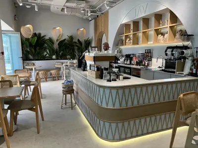 a restaurant with a counter and tables and chairs at Retaj Hotel in Amman