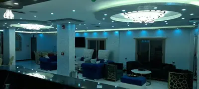 a lobby with blue lighting and couches and a bar at Venus Hotel in Wadi Musa