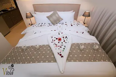 a bed with a heart shaped towel on it at Viola Hotel Suites in Amman