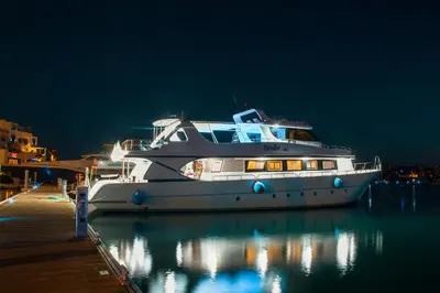 a boat is docked in the water at night at Aqaba Adventure Divers Resort & Dive Center in Aqaba