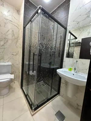 a bathroom with a shower and a toilet and a sink at Rumman Hotel in Madaba
