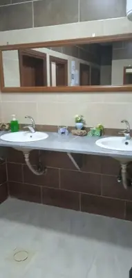 a bathroom with two sinks and two mirrors at Petra cabin Roof top hostel in Wadi Musa