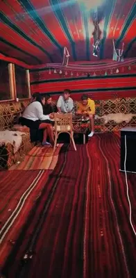 a group of people sitting at a table in a room at Happy Bedouin House Petra in Al Ḩayy