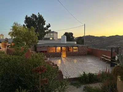 a house with a patio and a building at Happy Bedouin House Petra in Al Ḩayy