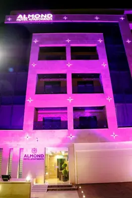 a building with pink lights on the side of it at Almond Hotel Apartments in Amman