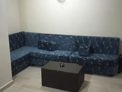 a blue couch in a living room with a table at Al haramain Furnished Apartments in Amman