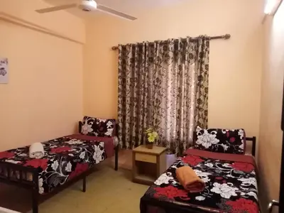 a living room with two beds and a window at Cliff Hostel in Amman